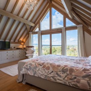 oak frame bedroom with vaulted ceiling and floor to ceiling glazing